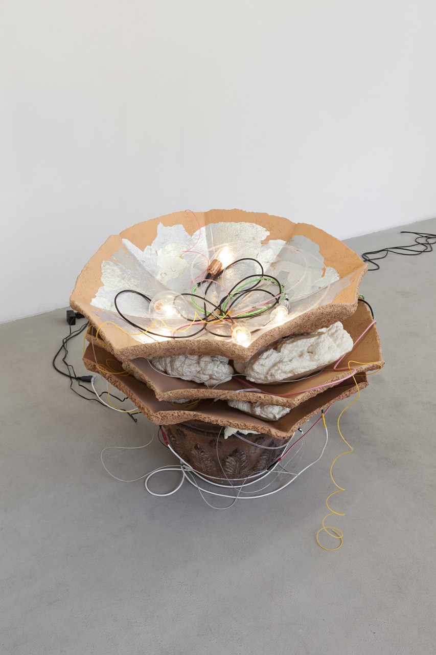 Amy Lien & Enzo Camacho, <i>Untitled, (CyberCeramic 2 Prototype Gluck50)</i>, 2015, two-part input-output sculpture. Part one: zucca “Marina di Chioggia,” zucca “bottiglia,” and zucchini “tromboncino d’Albenga” plants, soil, wooden sticks, plastic planters, plastic string, chipboard tables, sensors for light, temperature and humidity, Arduino and X-Bee wireless transmitter. Part two: found terra cotta planter, hand molded refratteria terra cotta umbrella casts, joss paper collage, polyurethane spray foam, electroluminiescent wires, LED lights with fiber optic attachments, incandescent light bulbs, Arduino and X-Bee wireless receiver, code for expressing sensory input, dimensions variable. Courtesy of Gluck50. Ph. Andrea Rossetti